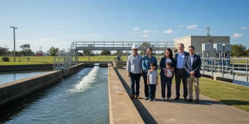 Community members and water professionals discussing new EPA water quality regulations near a treatment plant.
