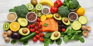 Colorful assortment of immune-boosting fruits and vegetables on a wooden table.